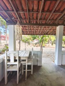 a wooden table and chairs under a wooden ceiling at Chalé em Tatajuba in Tatajuba