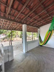 a room with a hammock hanging from a wall at Chalé em Tatajuba in Tatajuba
