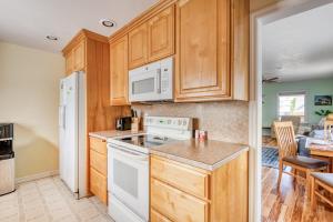 a kitchen with wooden cabinets and a white stove top oven at La Maison - Elegant 2BR Escape - Free Breakfast! in Albany