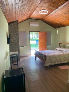 a bedroom with a bed and a stone wall at Pousada Sitio Roda D'Água Mairinque in Mairinque +64 photos