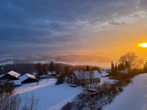 a winter sunset over a village with snow covered roofs at Ferienwohnung Kathi in Freyung