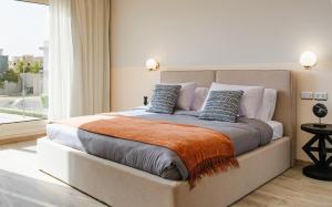 a bedroom with a large bed with an orange blanket at BirdNest at Sheikh Zayed in Sheikh Zayed