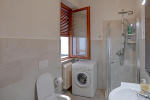 a bathroom with a toilet and a washing machine at Casa Niky in Verbania +7 photos