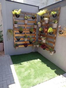 a garden with potted plants on a wall at Condomínio Flamboyant in Pindamonhangaba