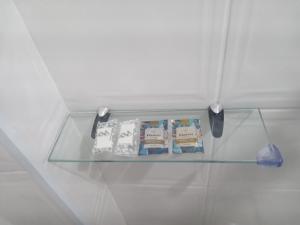 a glass shelf with three cakes and a knife at Condomínio Flamboyant in Pindamonhangaba
