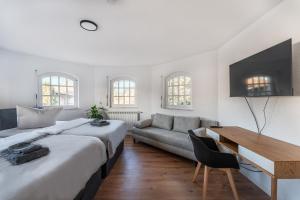 a bedroom with a bed and a desk and a couch at Check-In by BeOne RW-N in Rottweil