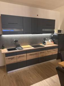 a kitchen with black cabinets and a counter top at Premiere Chalet in Vărşag