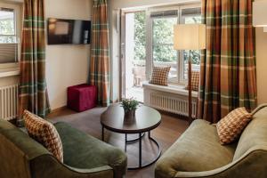 a living room with two couches and a table at Hotel Krone in Hayna