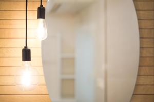 two light bulbs hanging from a wall with a surfboard at Hostal riMboMbin in Burgos