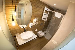 a bathroom with a sink and a mirror and a toilet at Hostal riMboMbin in Burgos