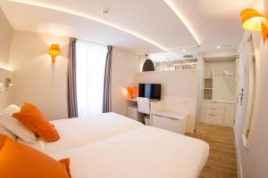 a bedroom with two beds and a desk with a television at Hostal riMboMbin in Burgos +36 photos
