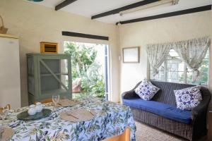 a living room with a bed and a couch at Douglas Drift Cottages in Underberg