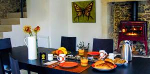a dining room table with food and a fireplace at La Demeure de Saint Fiacre in Saint-Fiacre-sur-Maine