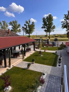 a garden with a pavilion and tables and chairs at Cazare & Restaurant Dalia in Socodor
