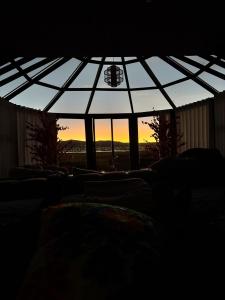 a room with a glass roof with the sunset in the background at Titicaca deluxe lodge in Puno