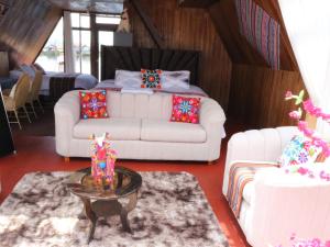 a living room with two white couches and a table at Titicaca deluxe lodge in Puno