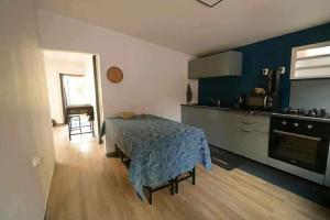 a kitchen with a table and a kitchen with a stove at La Maison des Cocotiers in Petite Île