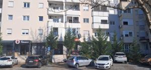 a group of cars parked in a parking lot in front of a building at Luxury Apartment-Aurora 33 Free Parking City Center in Podgorica