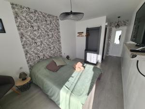 a bedroom with a bed with a pink stuffed animal on it at Le Petit Chêne in Orgnac-lʼAven
