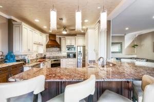a kitchen with white cabinets and a marble counter top at Sunkissed Oasis in Navarre