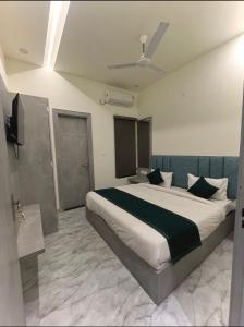 a bedroom with a large bed and a television at Hotel Divaa Inn in Mathura