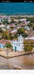 a white building in the water next to a town at Casas oliveira in Paraty