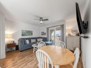 a living room with a table and a blue couch at Sea The Good condo in Carolina Beach