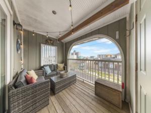 a living room with a couch and a balcony at Sea The Good condo in Carolina Beach