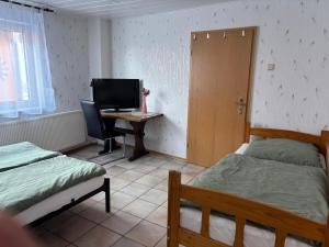 a bedroom with two beds and a desk with a computer at Ferien- & Monteurswohnung Krüger Werra Suhl Tal in Raßdorf
