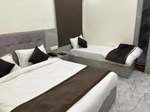 a hotel room with two beds in a room at Hotel Divaa Inn in Mathura +11 photos