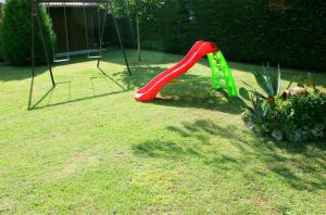 a playground with a red slide in a yard at Agriturismo La Piana in Castiglione del Lago