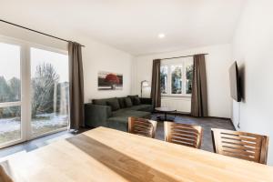 a living room with a couch and a table and chairs at Modernes Apartment in Mistelgau 3 in Mistelgau