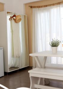 a white table with a plant on it next to a window at Santa Irini 2 in Vourvoúlos +1 photo