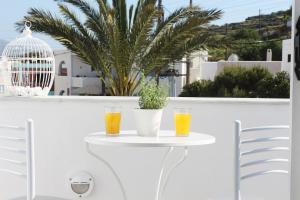 two glasses of orange juice on a white table on a balcony at Santa Irini 2 in Vourvoúlos