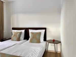 a bedroom with two beds and a side table at Appartements Waldrose in Titisee-Neustadt