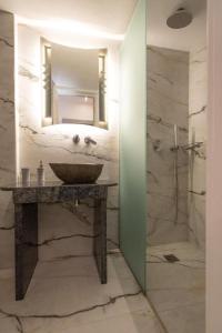 a bathroom with a sink and a shower with a mirror at Irini Studios in Psarou +48 photos