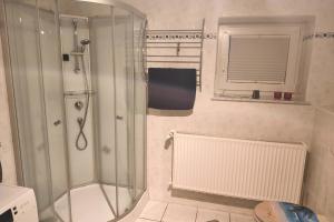 a bathroom with a shower with a glass door at Private room with own bathroom in Harsum