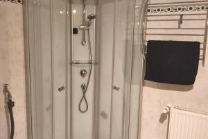 a shower with a glass door in a bathroom at Private room with own bathroom in Harsum