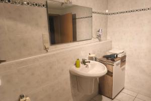 a white bathroom with a sink and a mirror at Private room with own bathroom in Harsum
