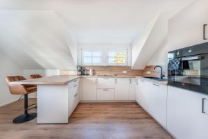 a kitchen with white cabinets and a wooden table at Check-In by BeOne RW-N in Rottweil