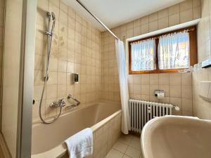 a bathroom with a tub and a sink at Appartements Waldrose in Titisee-Neustadt +14 photos