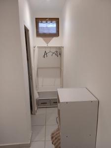 a white room with a refrigerator and a window at Le Lohan in Port-Saint-Louis-du-Rhône +2 photos