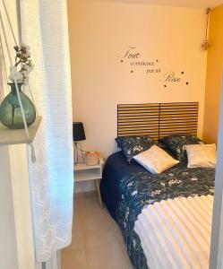 a bedroom with a bed and a vase on a table at Aéroport à pied, Escale 25 in Tillé
