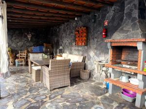 a living room with a stone wall with a fireplace at Casa do Sol in Safara