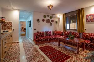 a living room with a red couch and a table at Dar jawhara in Chefchaouen