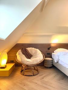a room with a bed and a chair in a attic at Staf Vakantiewoning 8 ps De Haan centrum in De Haan
