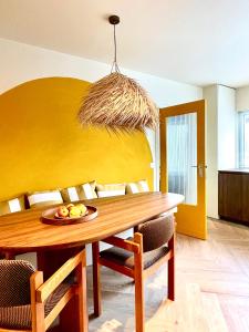 a dining room table with a plate of fruit on it at Staf Vakantiewoning 8 ps De Haan centrum in De Haan