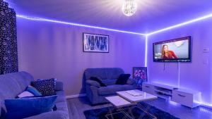 a living room with two couches and a flat screen tv at Entire 3 bedroom luxurious house, Wigan , Manchester in Wigan