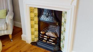 a fireplace in the corner of a room at Stunning 2 Bed Georgian Apartment in North Walsham