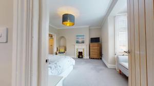 a bedroom with a bed and a dresser and a window at Stunning 2 Bed Georgian Apartment in North Walsham